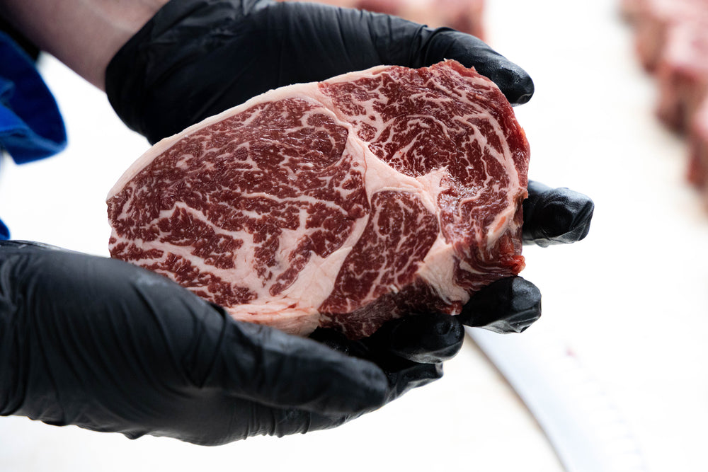 Winterfrost American Wagyu Ribeye steak, held to show marbling